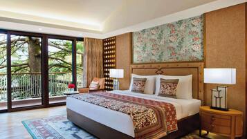 A spacious bedroom with a large bed, a nightstand, a chair, and a view of the outdoors through a sliding door.