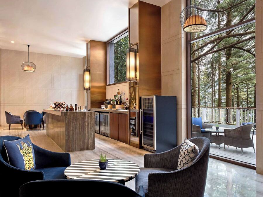 Eine moderne Küche mit Barbereich, großen Fenstern und einem Balkon mit Sitzgelegenheit.