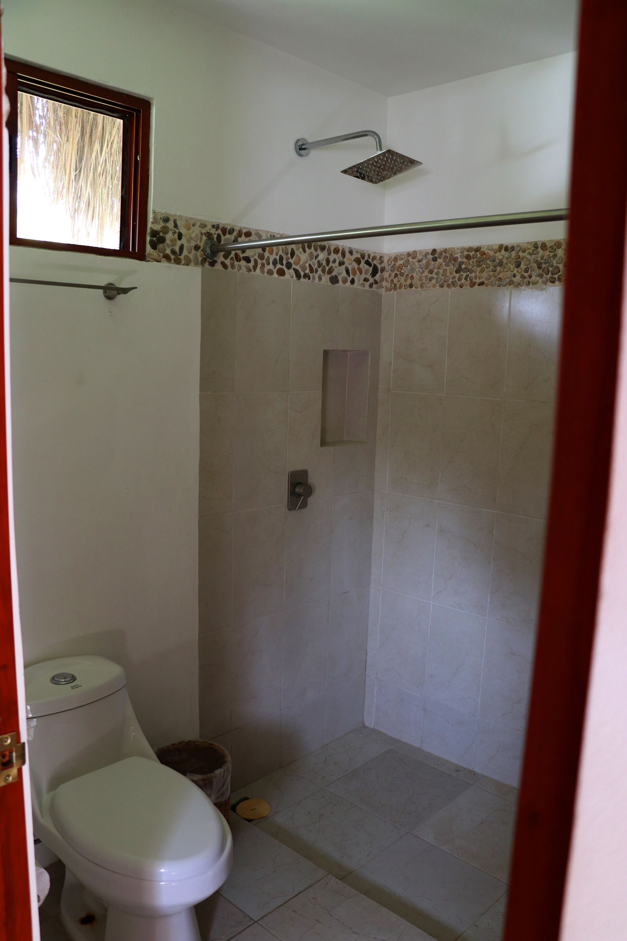 A bathroom with a toilet, shower, and tiled walls.