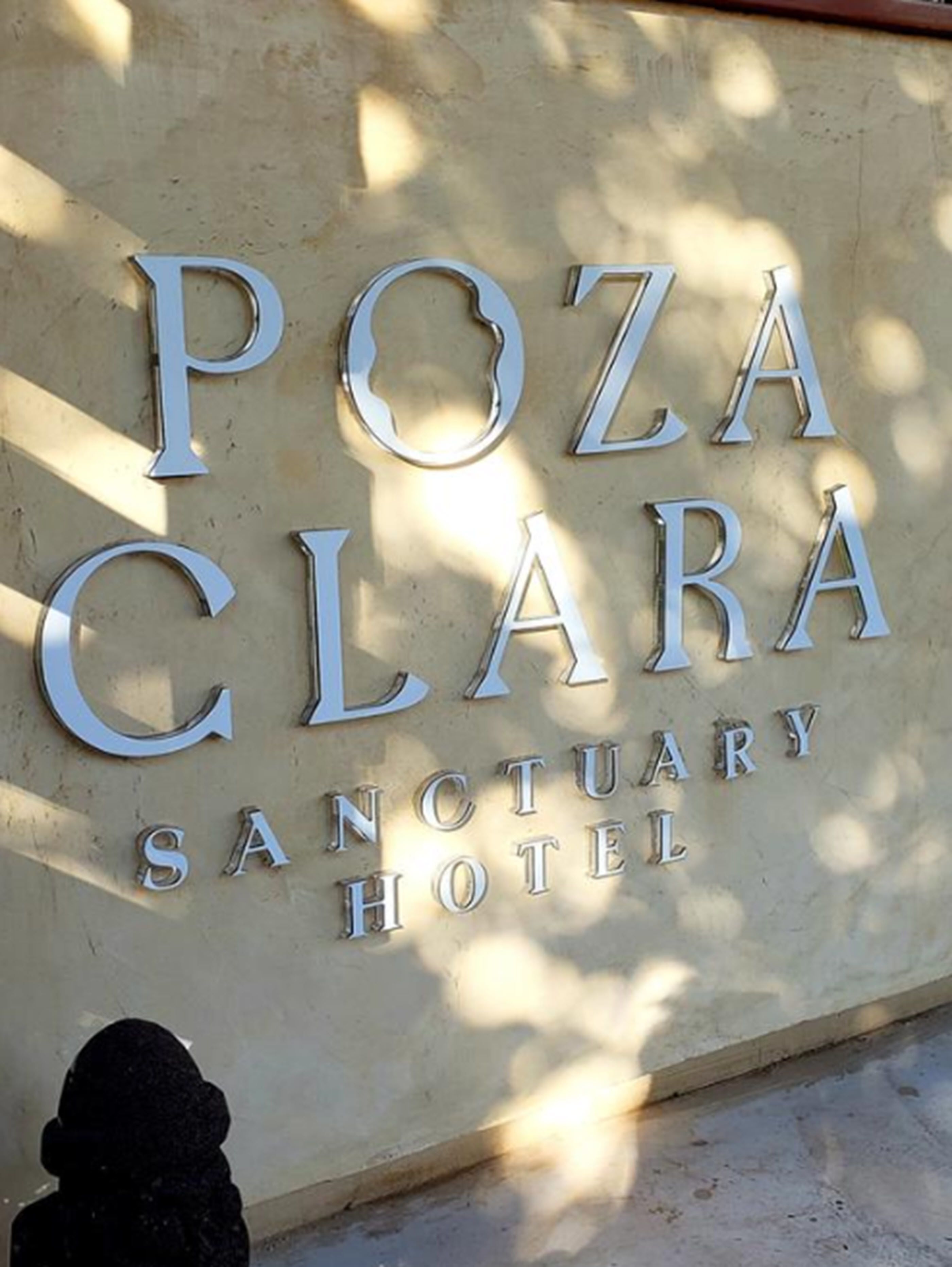Letrero del Hotel Santuario Poza Clara, con letras metálicas grandes.