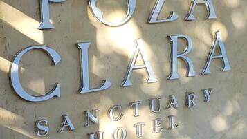 Letrero del Hotel Santuario Poza Clara, con letras metálicas grandes.