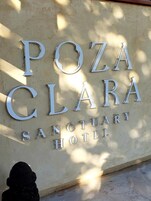 Letrero del Hotel Santuario Poza Clara, con letras metálicas grandes.