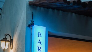 A bar sign on a building with hanging lights and chairs inside. - Poza Clara Sanctuary Hotel (Bacalar)