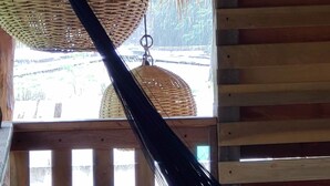 A hammock hanging from a wooden ceiling with thatched roof and wooden slats. - Poza Clara Sanctuary Hotel (Bacalar)