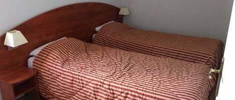 A single bed with a wooden headboard and two bedside lamps.