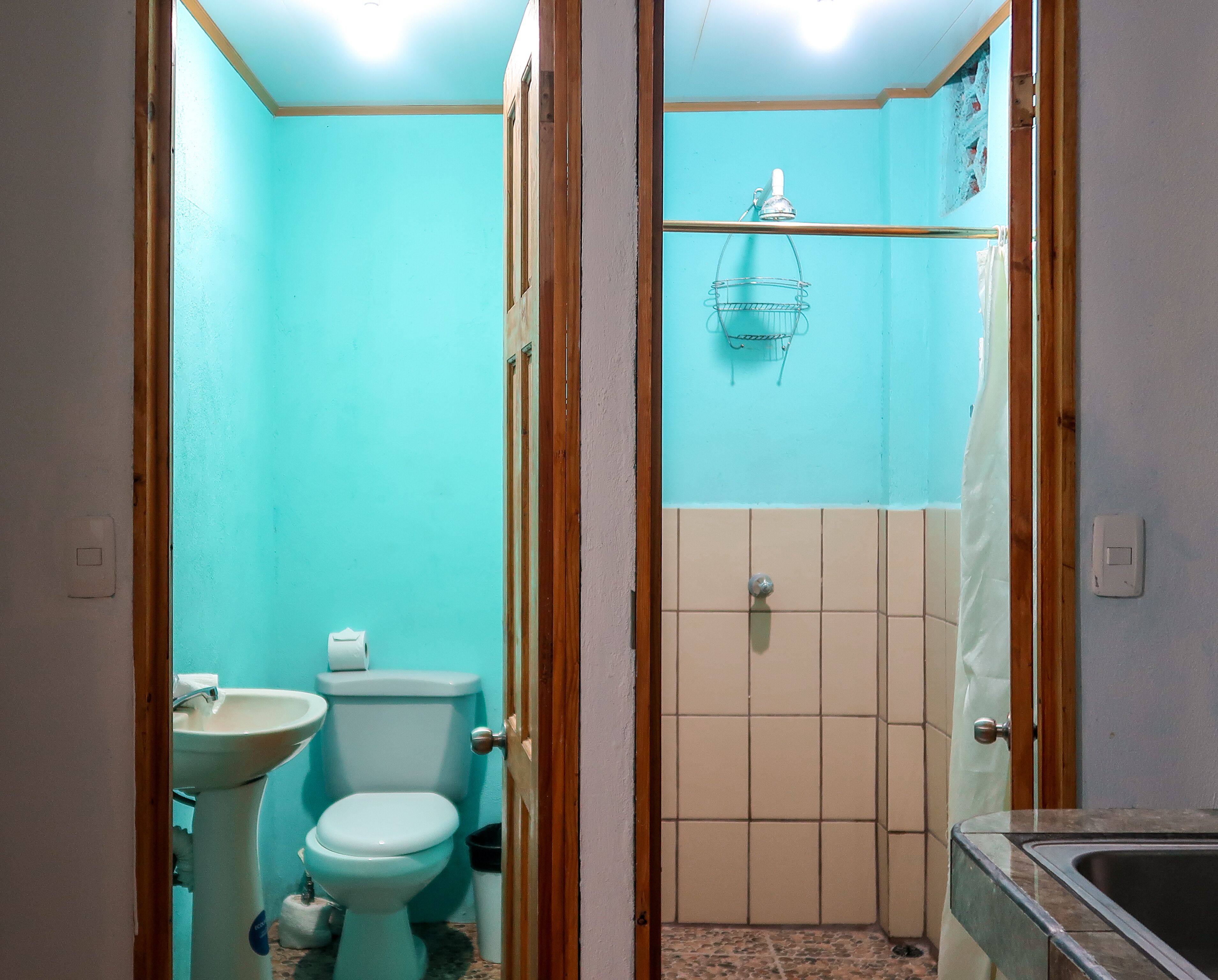 A small bathroom with a toilet, sink, and shower.