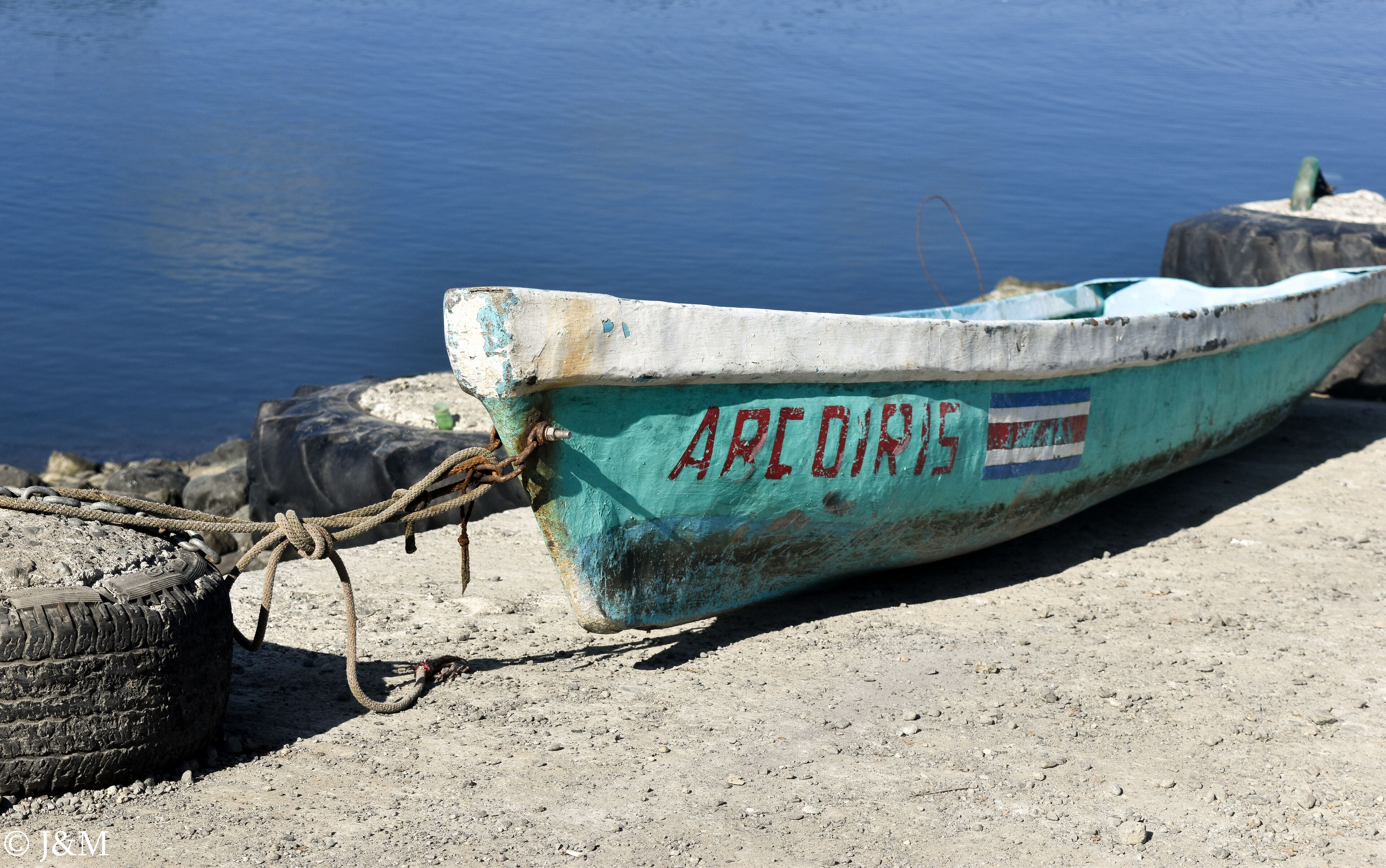 Een boot vastgemaakt aan een rotsachtige kust, met de naam 'ARODIS' op de zijkant.