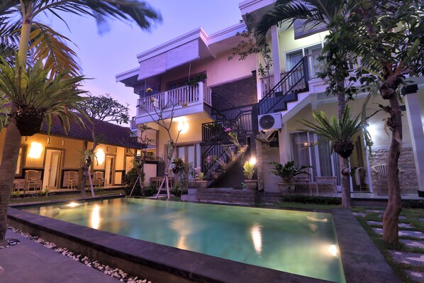 A multi-story building with a swimming pool, outdoor seating, and a staircase leading to the upper floors. - Ons Canggu (Tibubeneng)