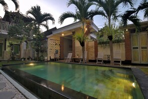 A swimming pool with lounge chairs and palm trees. - Ons Canggu (Tibubeneng)
