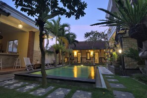 A pool area with a clear view of the pool, lounge chairs, and surrounding greenery. - Ons Canggu (Tibubeneng)