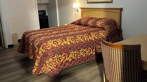 A hotel room with a bed, a chair, a microwave, and a painting on the wall. - New West Motel (SeaTac)