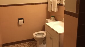 Une petite salle de bain avec des toilettes, un lavabo et un miroir.
