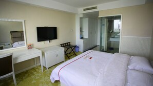A hotel room with a bed, a desk, a chair, a television, and a mirror. - Jiaxing ShiMao Inn (Jiaxing)