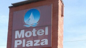 A sign for Motel Plaza with a sailboat logo. - Motel Plaza (Vermilion)