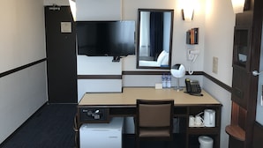 A hotel room with a desk, chair, minibar, clock, television, mirror, and a door with a handle. - Toyoko Inn Ulaanbaatar (Ulaanbaatar)