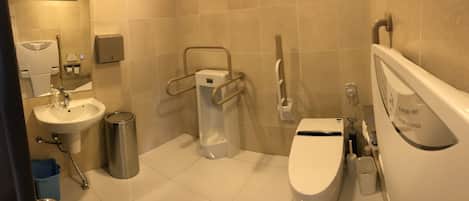 A modern bathroom with a sink, toilet, and bidet.