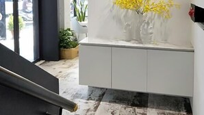 A modern interior with a staircase, a white console table with yellow flowers, and a view of the outside. - Small Hotel (Luodong)