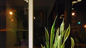 A dining area with a round table, a potted plant, and a chair. - Small Hotel (Luodong)