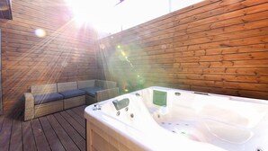 A wooden deck with a hot tub and a wicker sofa. - Hotel The Vizit Jeonju (Jeonju)