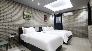 A modern hotel room with two beds, a small table, a nightstand, and a skylight. - Hotel The Vizit Jeonju (Jeonju)