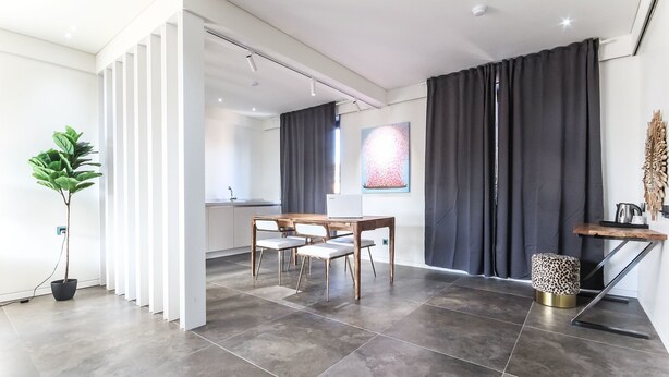 A modern interior with a dining area, a potted plant, and a view of the kitchen. - Hotel The Vizit Jeonju (Jeonju)