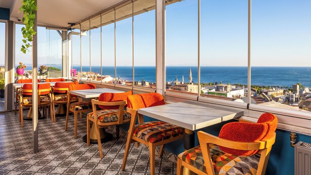 A terrace with tables and chairs, overlooking a coastal cityscape. - Sultanahmet Nu Hotel (Istanbul)