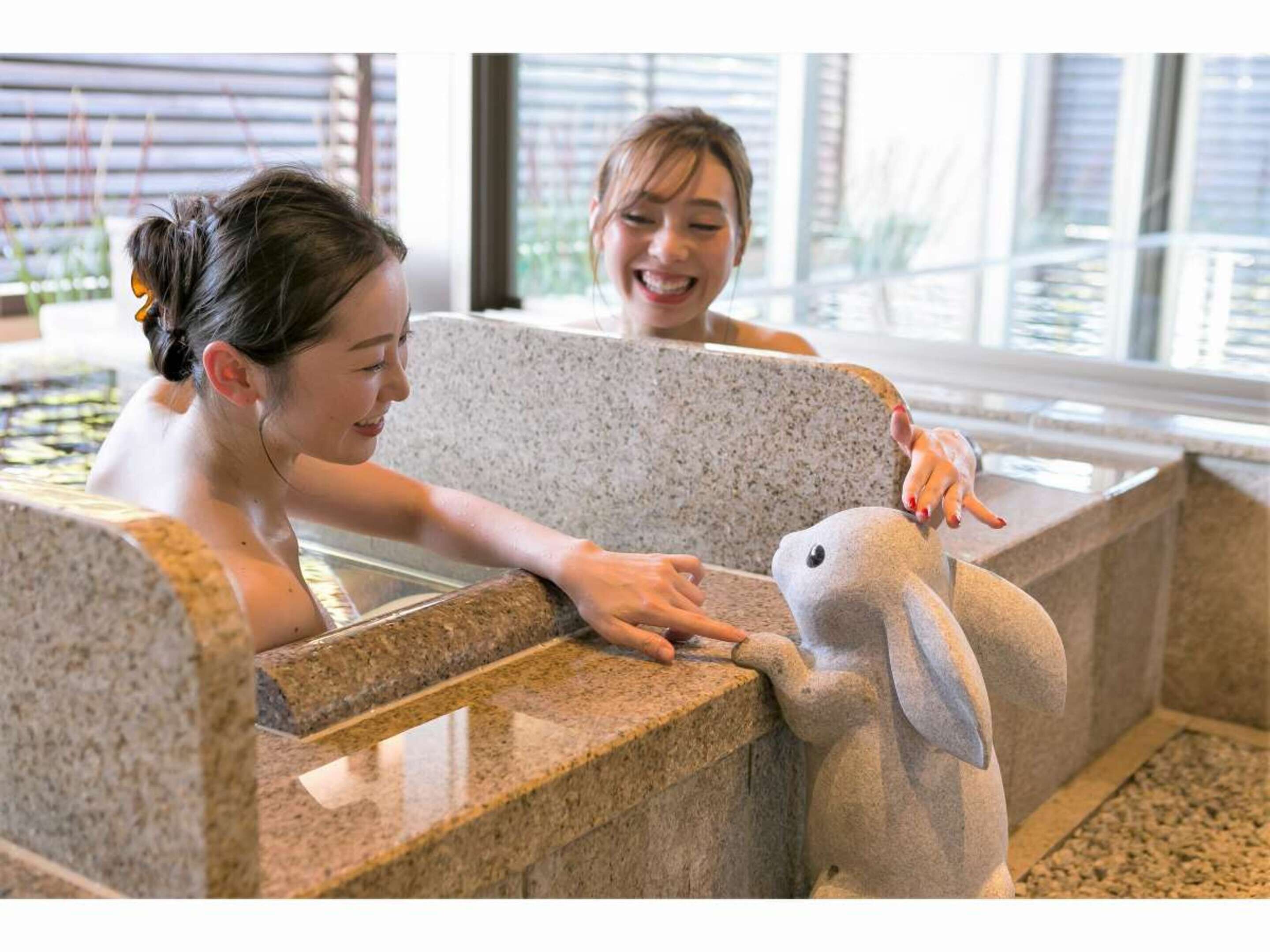 A spa area with a stone bench and a stone sculpture of a bird.