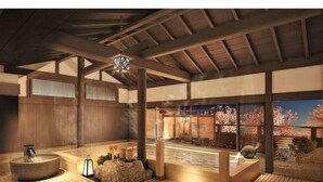 Un onsen japonés tradicional con vigas de madera, un manantial termal de piedra y vistas a flores de cerezo a través de una ventana.