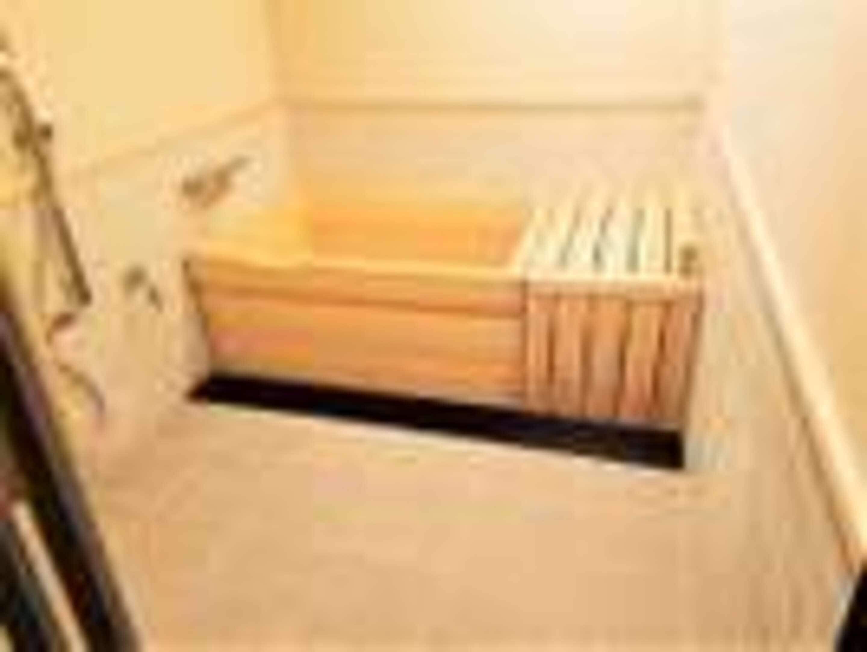 A small, narrow bathroom with a wooden bench and a radiator.