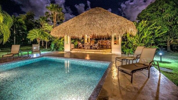 A pool area with lounge chairs and a thatched-roof structure. - Casa Las Brisas A Caribbean Vacation Dream (Cabarete)