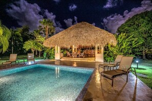 A pool area with lounge chairs and a thatched-roof structure. - Casa Las Brisas A Caribbean Vacation Dream (Cabarete)
