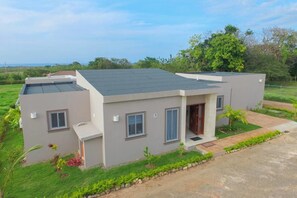 A modern two-story house with a flat roof, a front porch, and a small garden area. - A Great Place to Relax, Sunbathe and Enjoy Life (Sosúa)