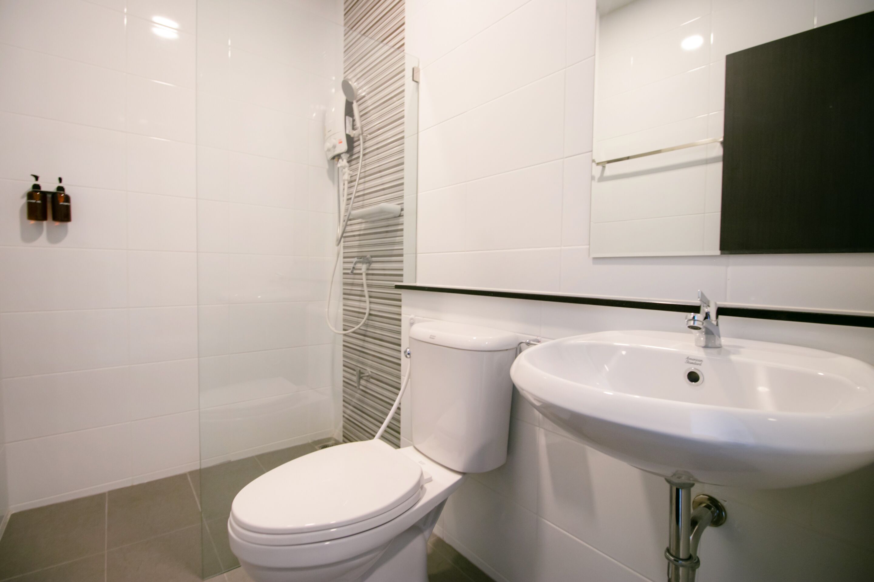 Une salle de bain moderne équipée de toilettes, d’un lavabo et d’une douche.