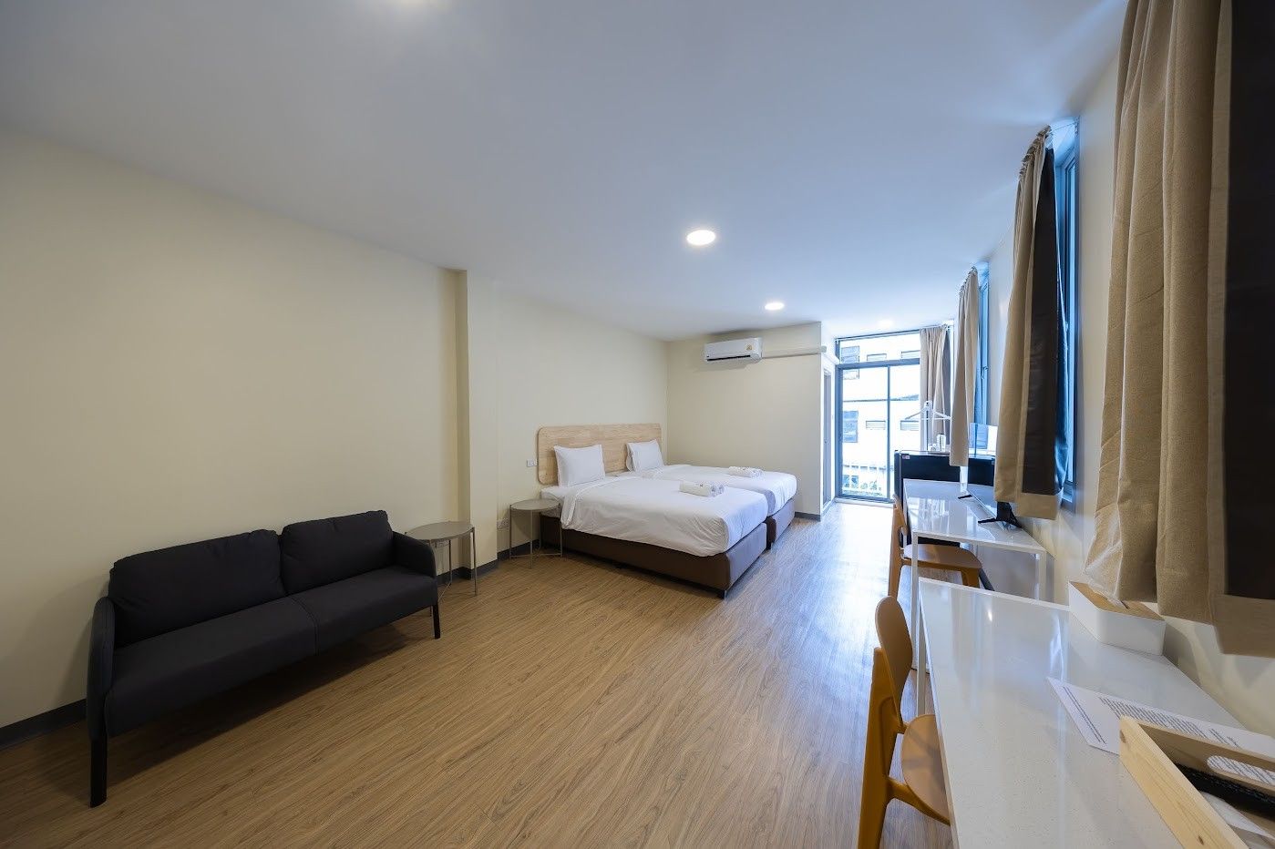 Una habitación de hotel con una cama, un sofá, un escritorio y una silla.