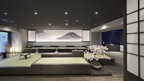 Un interior moderno con una zona de estar, un mural grande y una decoración vegetal.