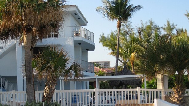 A modern building with a white exterior, multiple balconies, and a covered outdoor area. - Just steps to the Warm Sandy Beach of Southern Florida (Pompano Beach)
