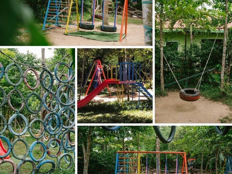 A playground with tire swings, a slide, and a climbing structure.