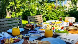 A table set outdoors with various dishes, drinks, and bread. - Triada Hotel Buyukada (Adalar)