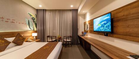 Habitación de hotel con cama, escritorio, televisor y una pared con una cita.
