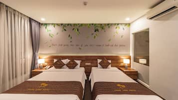 Habitación de hotel con dos camas, un espejo grande y una pared con una cita motivacional.