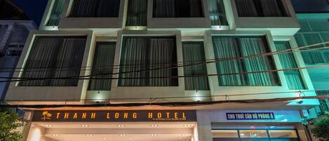 A modern hotel with a prominent entrance, multiple floors, and a well-lit facade.