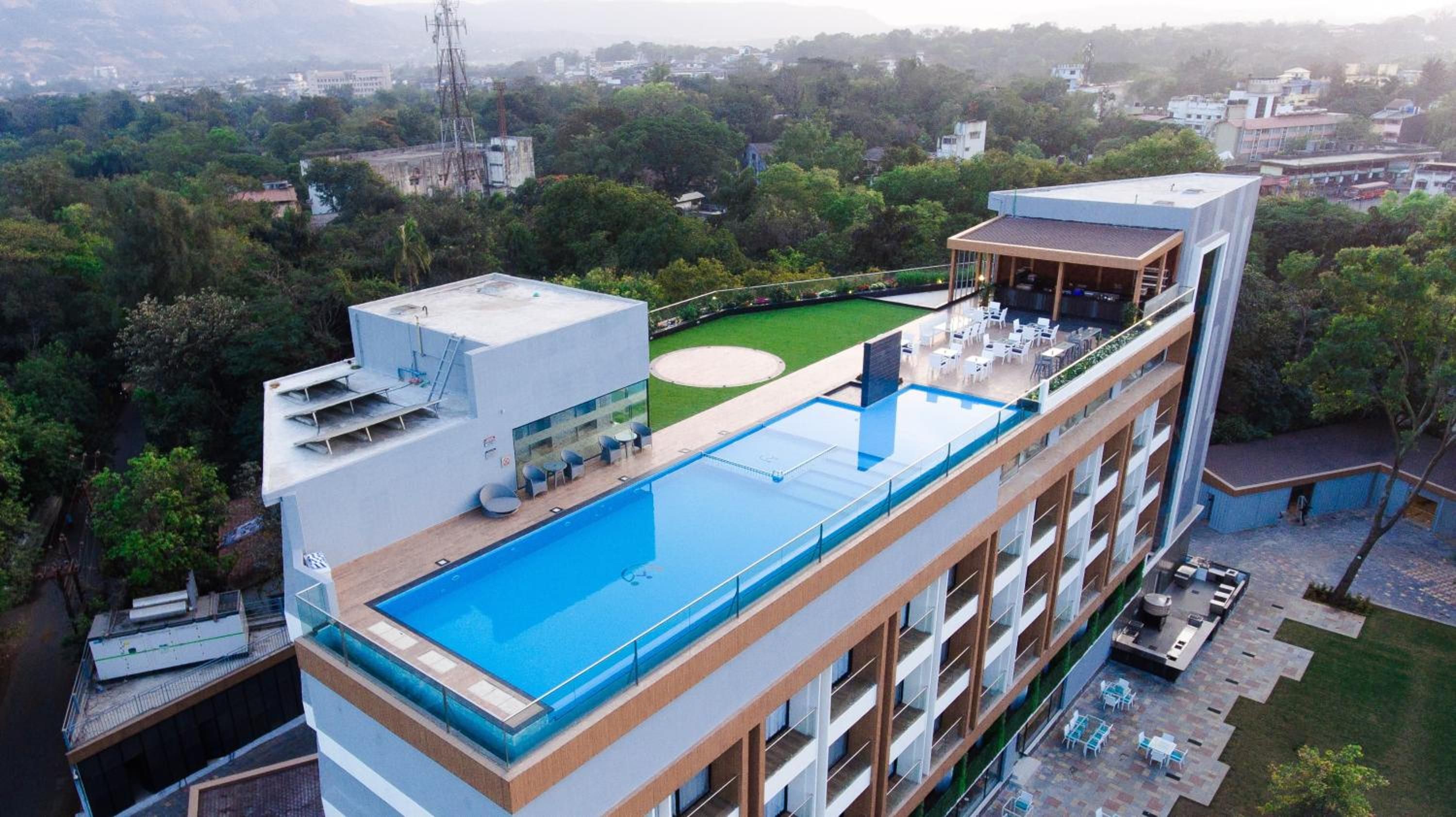 A modern building with a rooftop swimming pool and outdoor seating area.
