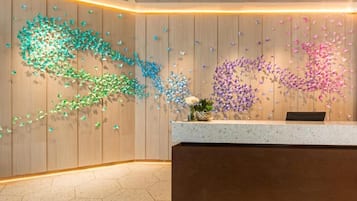 A reception area with a wooden wall and a decorative butterfly installation.