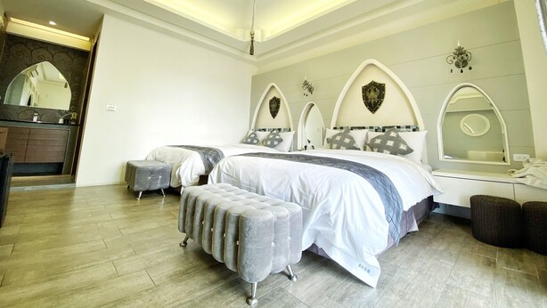 A bedroom with a large bed, a vanity with a mirror, and a chandelier. - Dream Ocean View B&B (Magong)