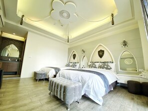 A bedroom with a large bed, a vanity with a mirror, and a chandelier. - Dream Ocean View B&B (Magong)