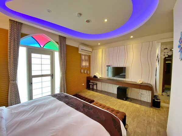 A modern hotel room with a large bed, a TV, a small desk, and a bathroom. - Dream Ocean View B&B (Magong)