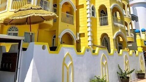 A yellow building with multiple balconies and arched windows. - Dream Ocean View B&B (Magong)