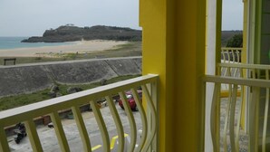 A balcony with a view of a beach and a hill. - Dream Ocean View B&B (Magong)