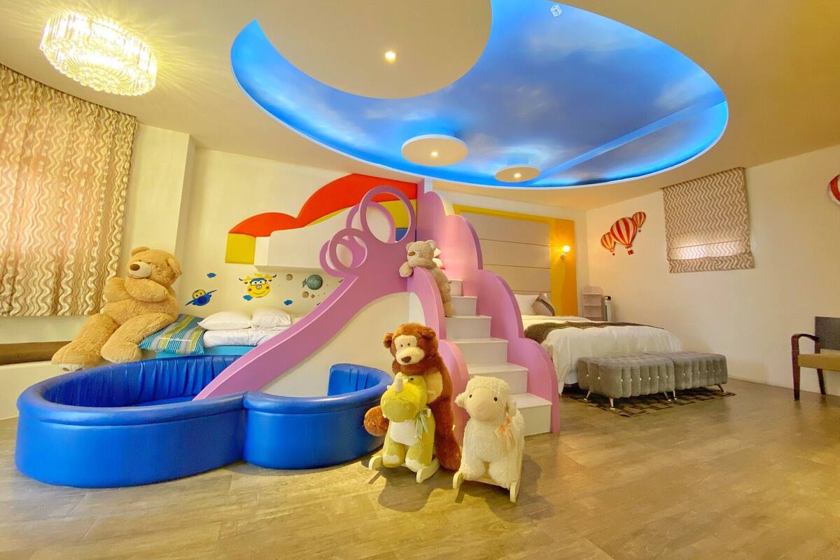 A child's play area with a slide, a bed, and a sofa.