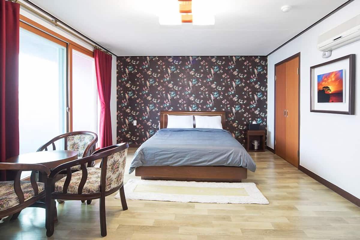 Un dormitorio con cama, escritorio y sillas.